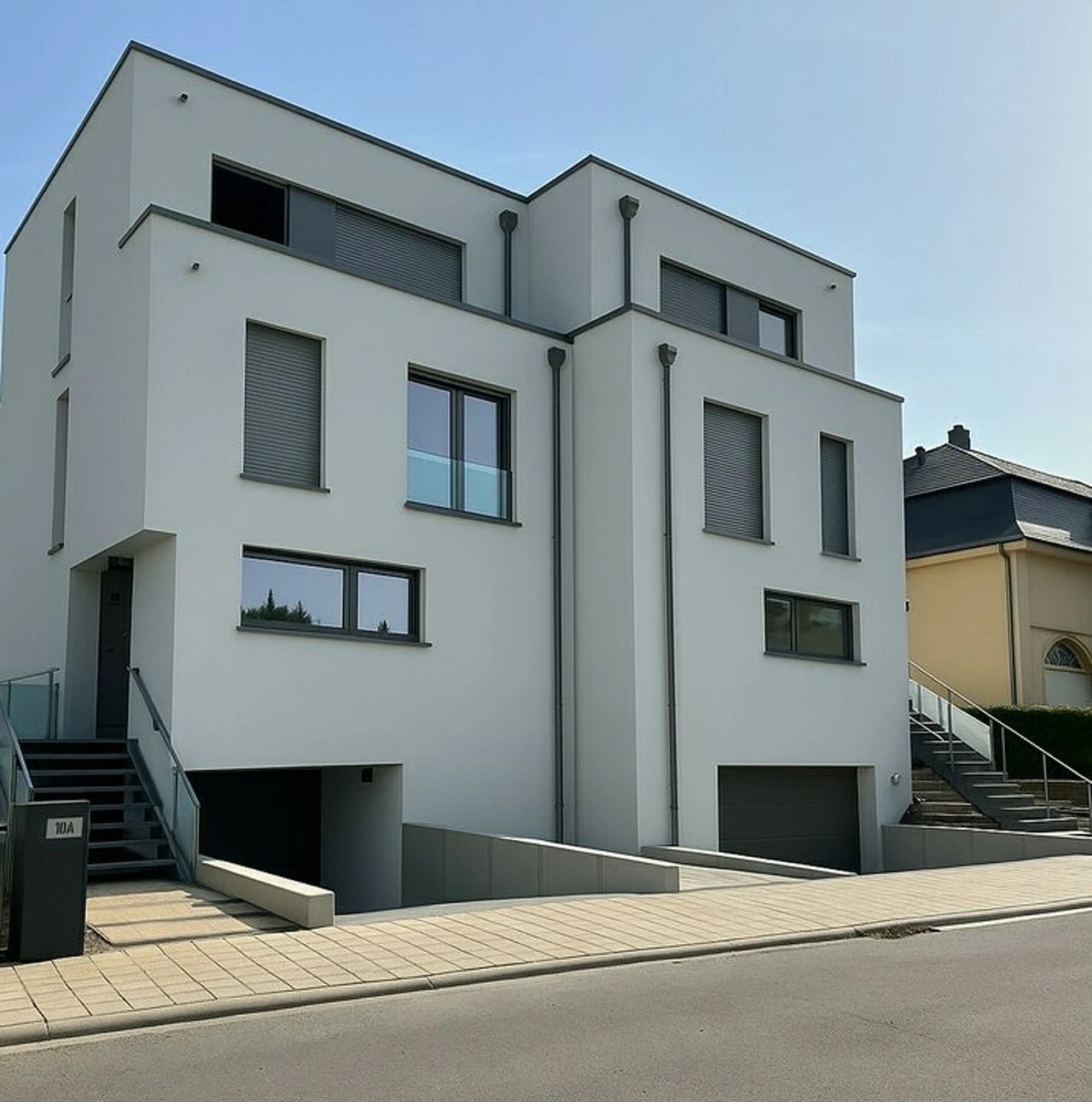 Façades avant de maisons modernes avec garages et escaliers extérieurs