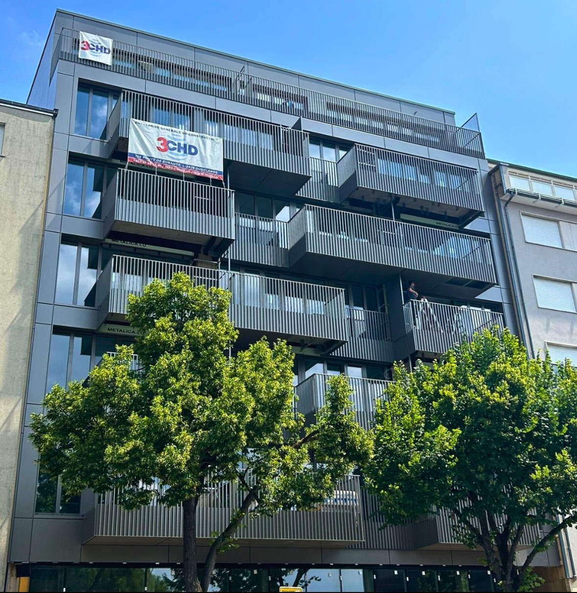 Façade moderne avec terrasses en saillie et brise-soleil métalliques de la résidence